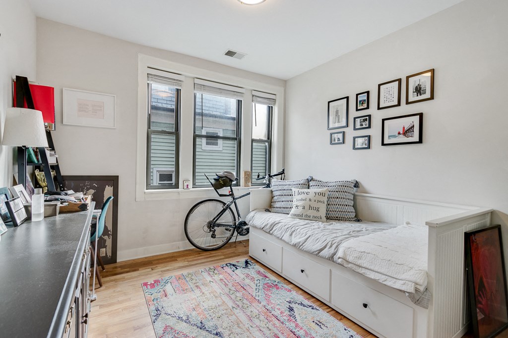 a bedroom with a bed and a bike in the corner