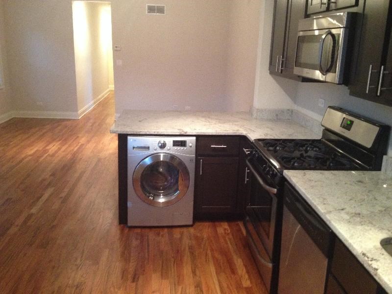 an empty kitchen with a washing machine in it