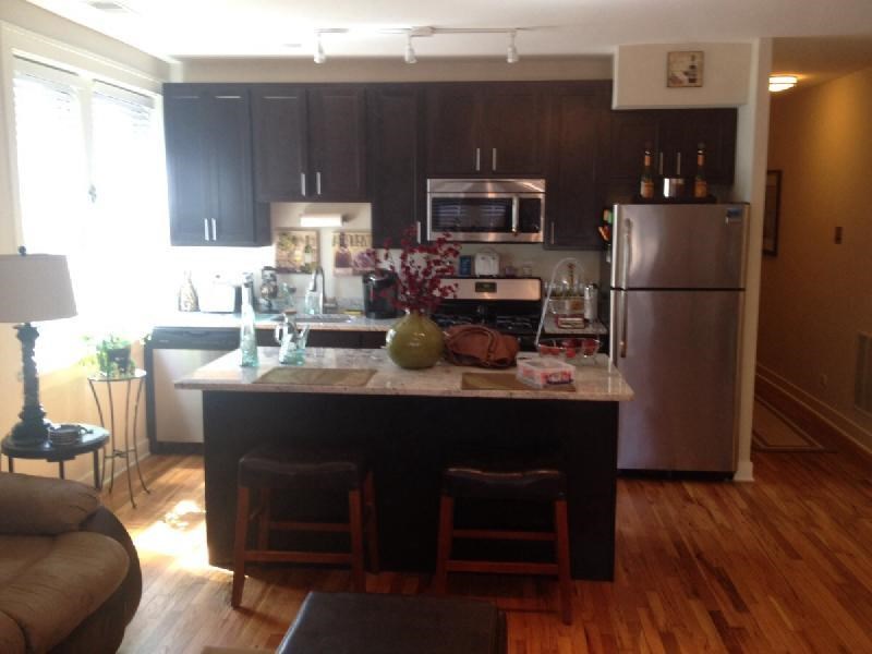 a kitchen with a center island and a stainless steel refrigerator