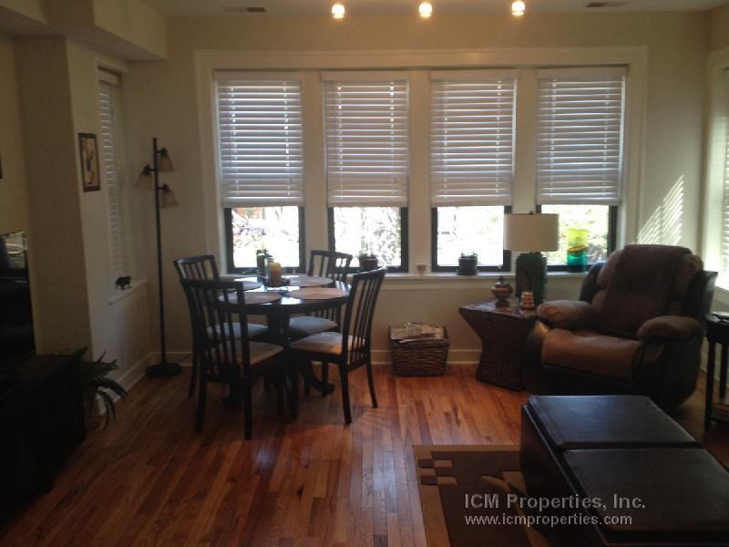 a living room and dining room with a table and chairs