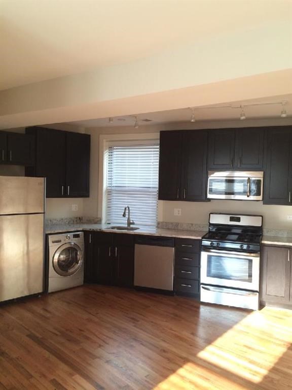 a kitchen with black cabinets and stainless steel appliances