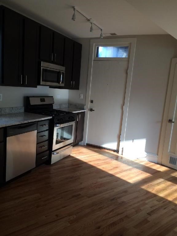 a kitchen with wooden floors and a door with a window
