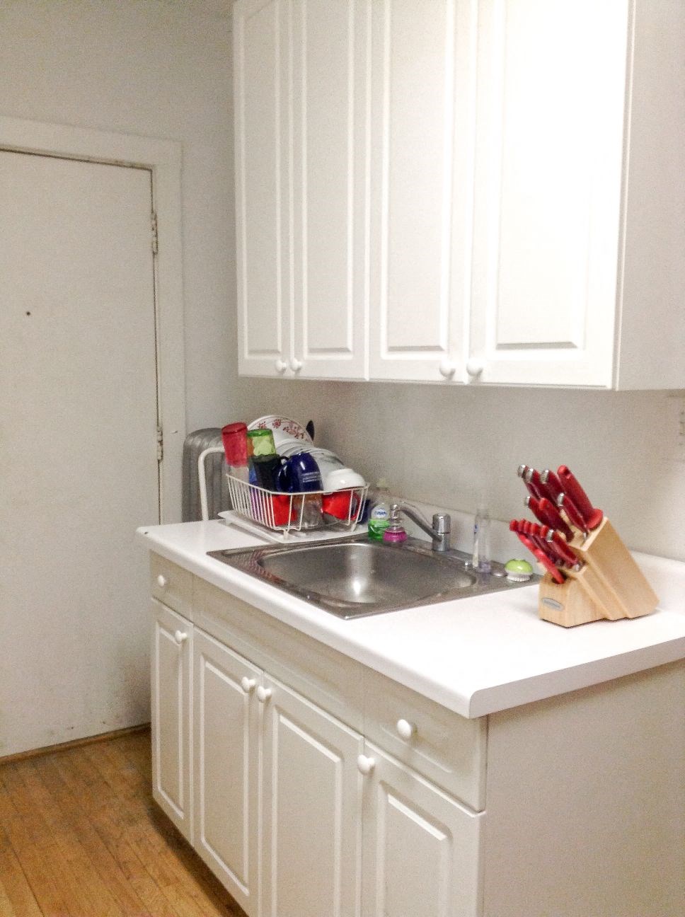 a small kitchen with a sink and white cabinets