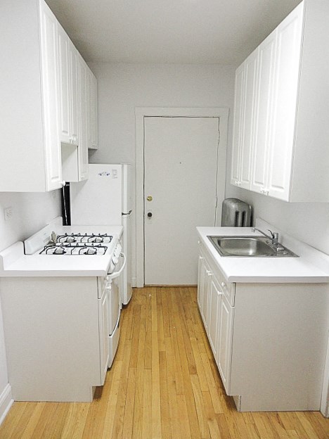 a small kitchen with white cabinets and a stove and a sink