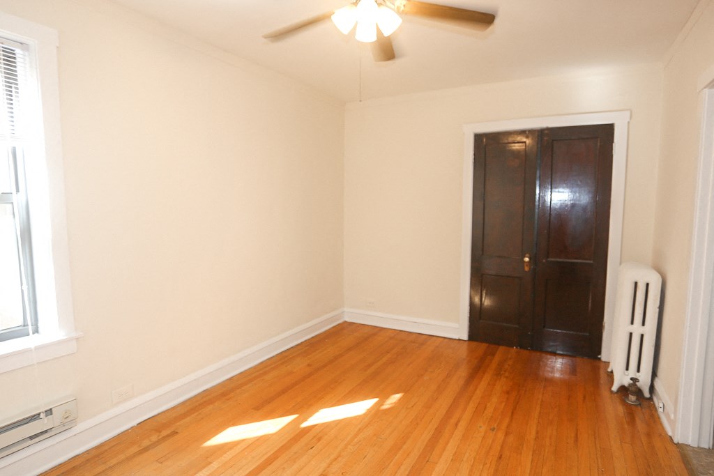 an empty living room with wood floors and a black door