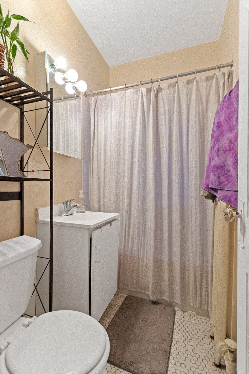 a bathroom with a toilet and a sink and a shower