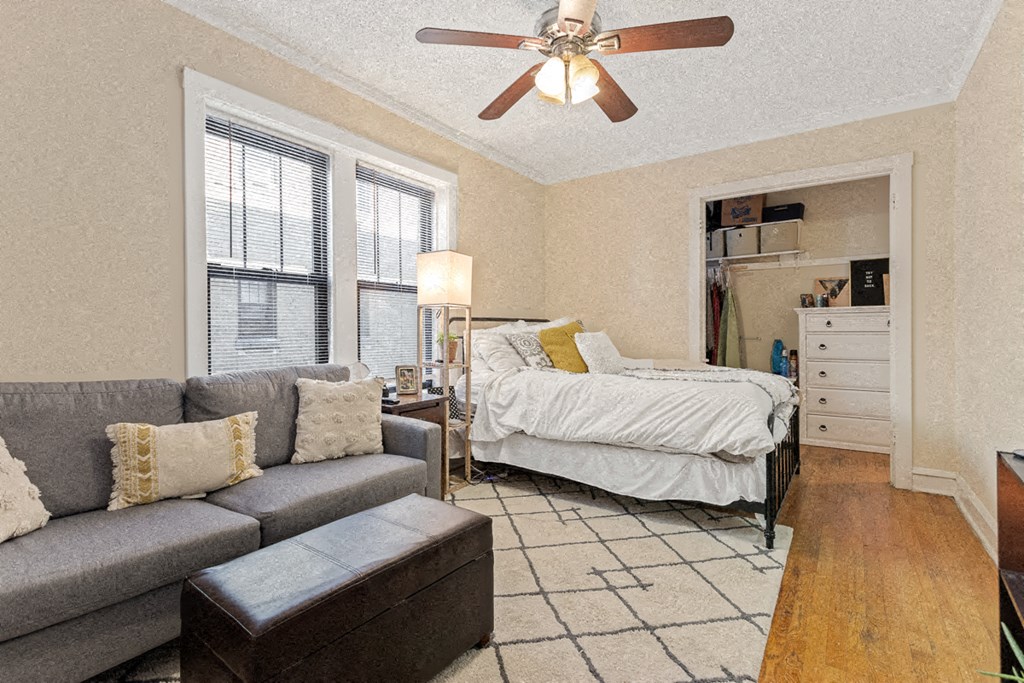 a bedroom with a bed and a living room with a couch