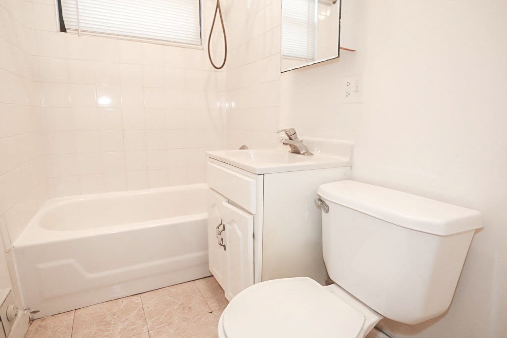 a bathroom with a toilet and a sink and a bath tub