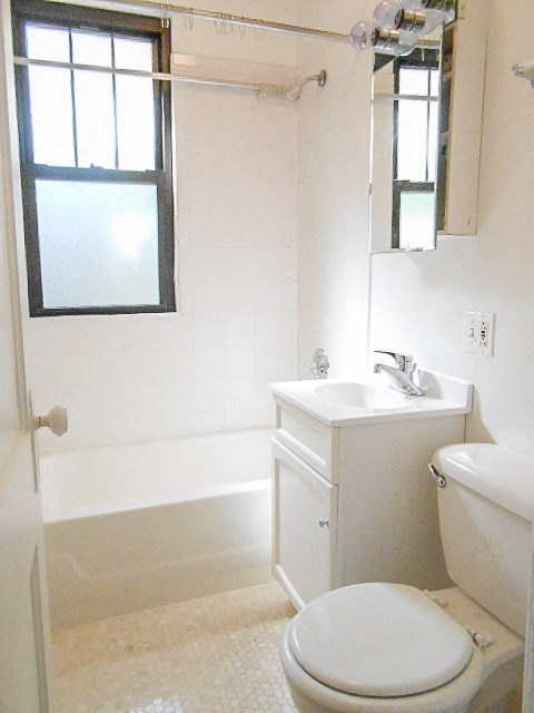 a bathroom with a toilet and a sink and a window