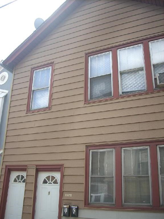 a brown house with windows and a white door