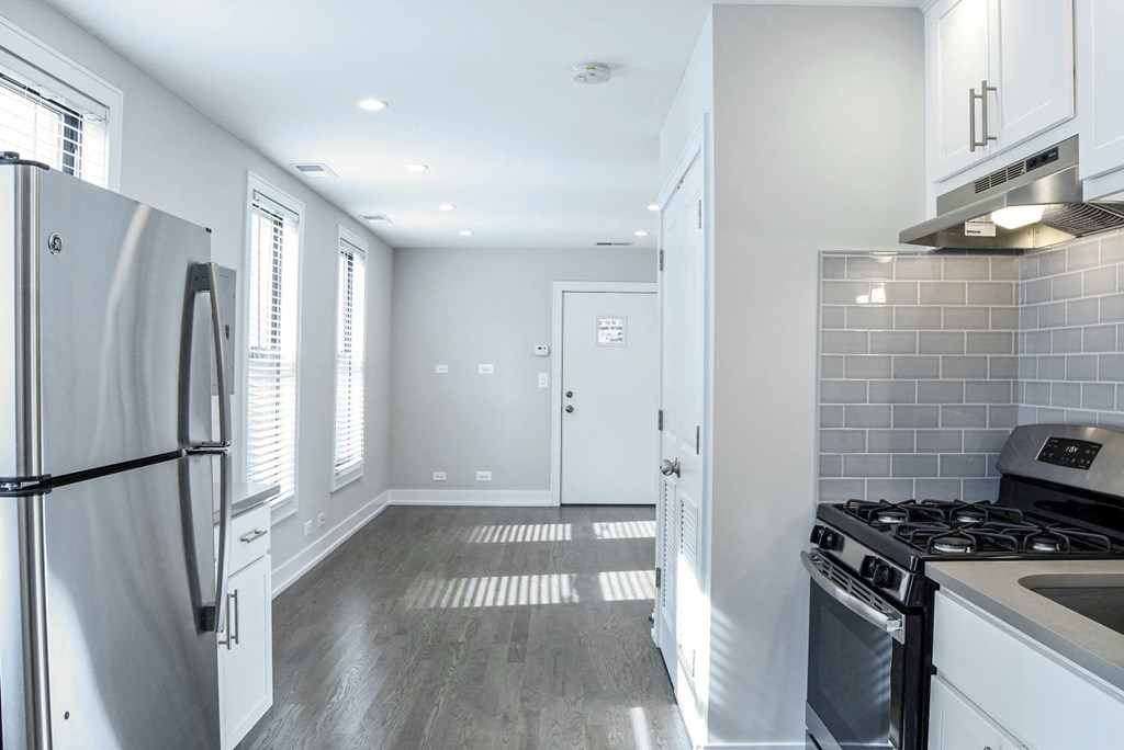 a renovated kitchen with white cabinets and stainless steel appliances