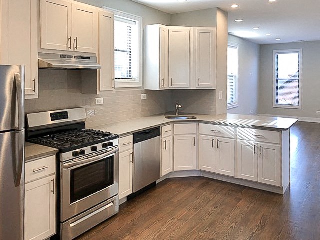 a kitchen with white cabinets and stainless steel appliances