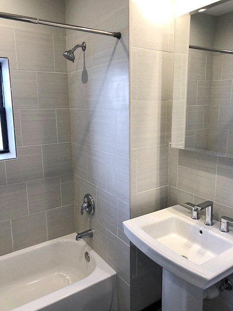 a bathroom with a sink and a bath tub and a mirror