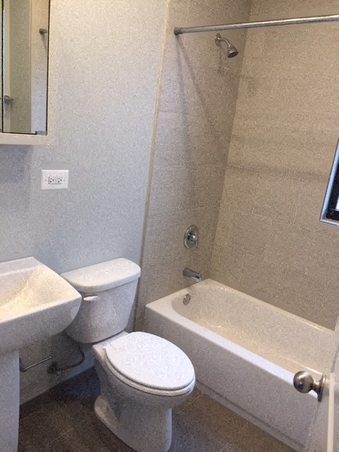 a bathroom with a toilet and a tub and a sink