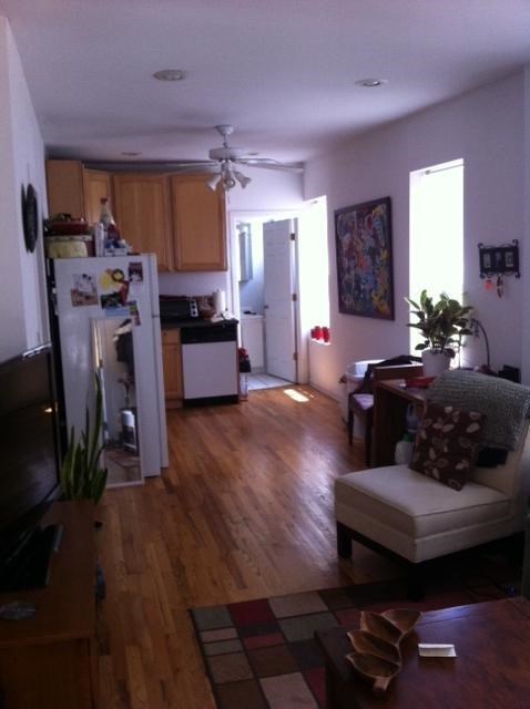 a living room and kitchen with a hard wood floor