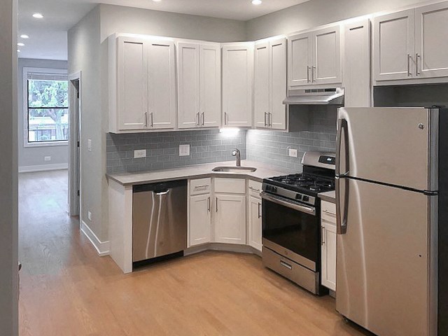 a kitchen with stainless steel appliances and white cabinets