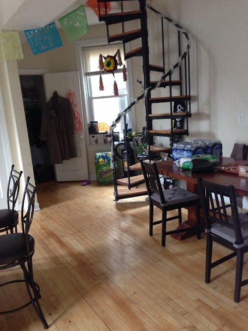 a living room with a spiral staircase and a table and chairs