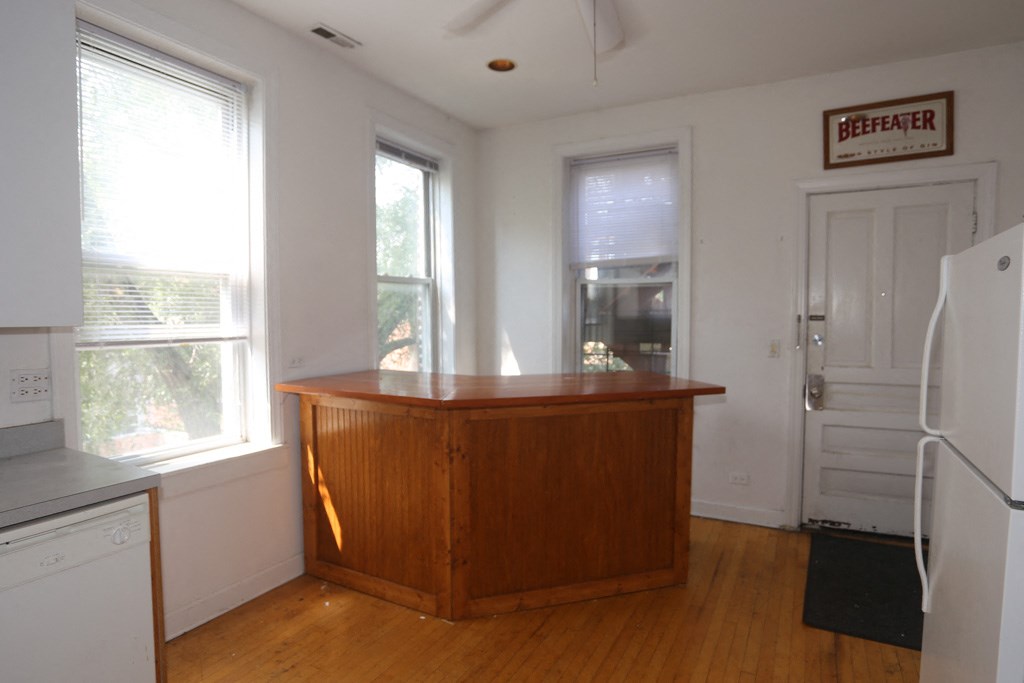 an empty kitchen with a bar in the center of it