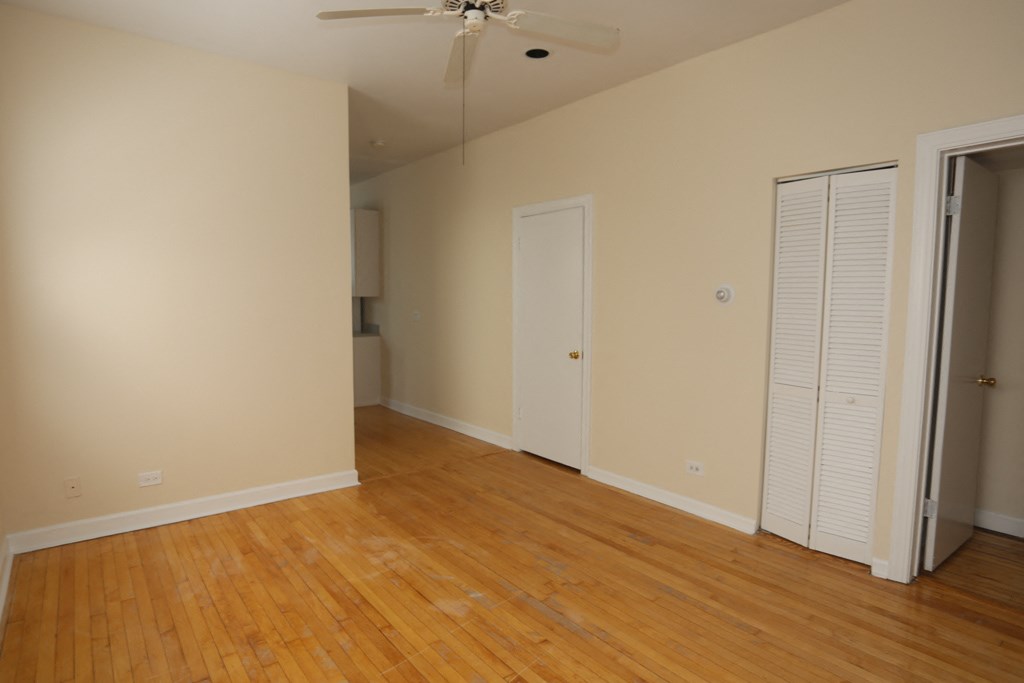 an empty living room with wood floors and a closet