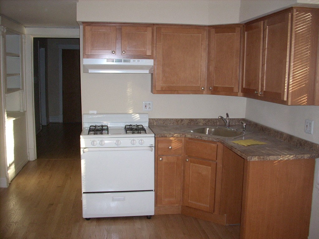 an empty kitchen with a stove and a sink
