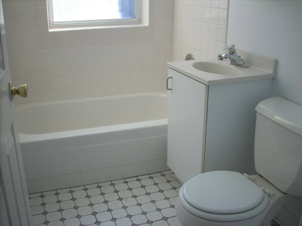 a white bathroom with a sink toilet and bath tub