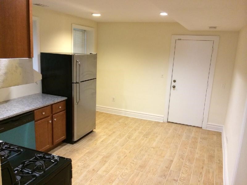 an empty kitchen with a stainless steel refrigerator