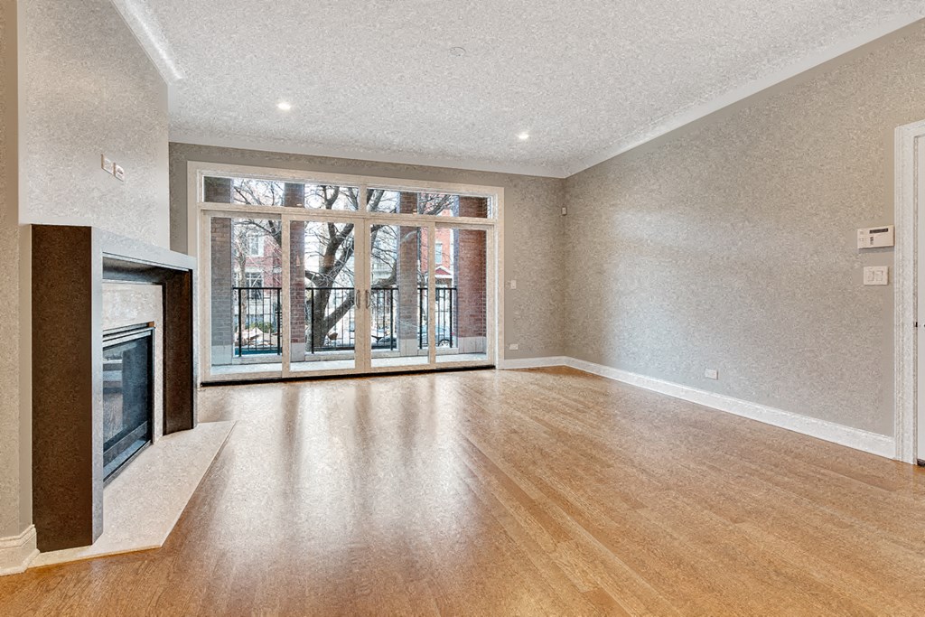an empty living room with a fireplace and a window