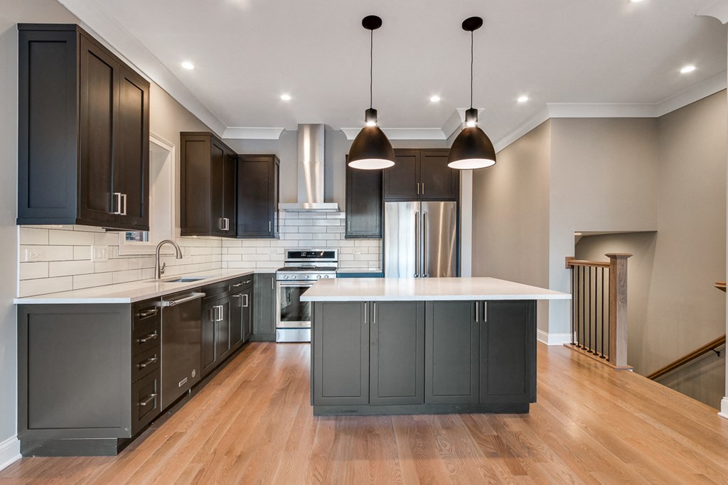 a kitchen with dark cabinets and a white counter top