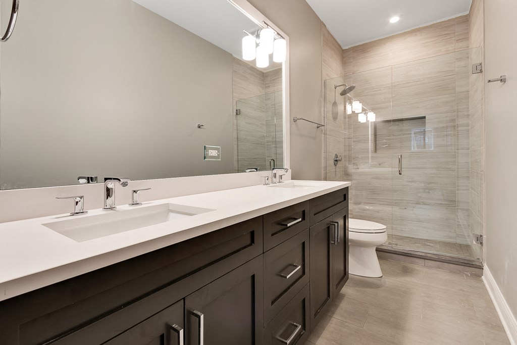 a bathroom with two sinks and a shower and a toilet