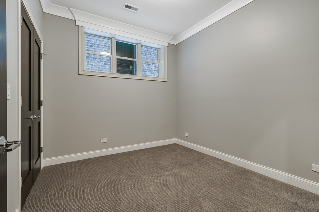 an empty room with carpet and a window