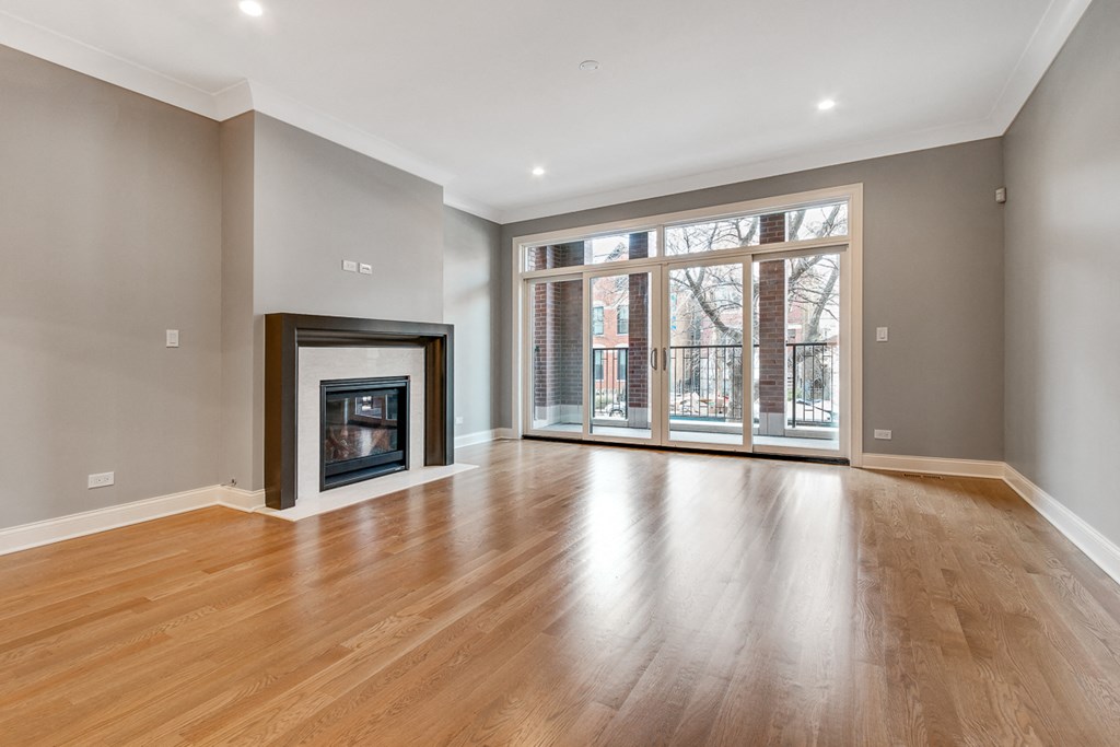 a living room with a fireplace and a sliding glass door to a balcony