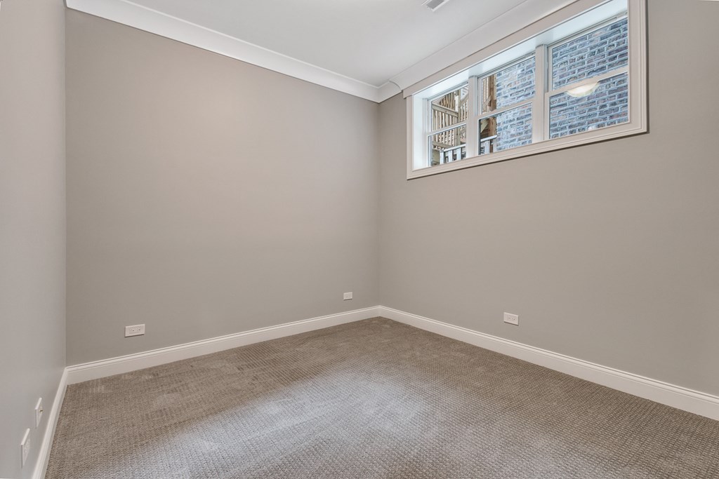 an empty room with carpet and a window