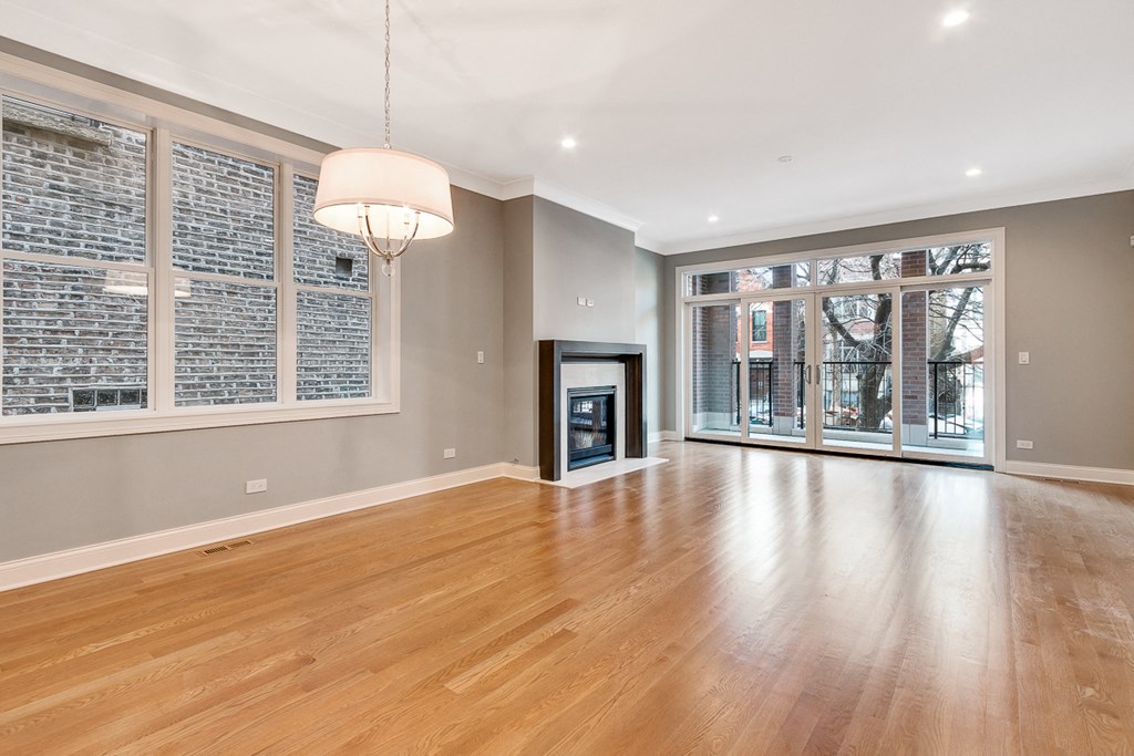an empty living room with a fireplace and a large window