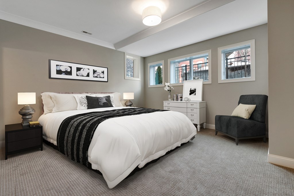 the master bedroom has neutral colors and a large bed