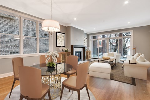 a living room with a glass dining room table and a fireplace
