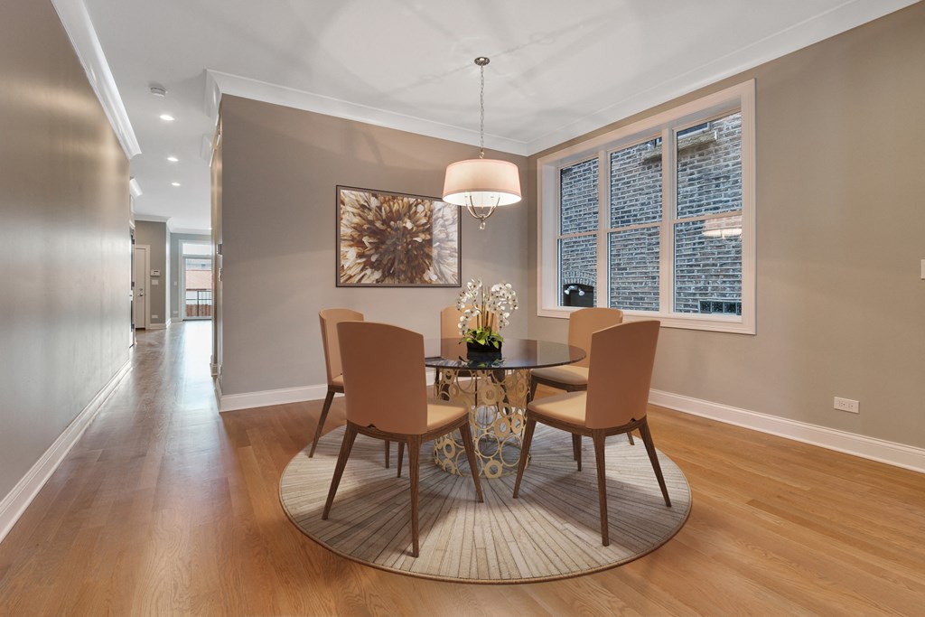 a dining room with a table and chairs and a large window