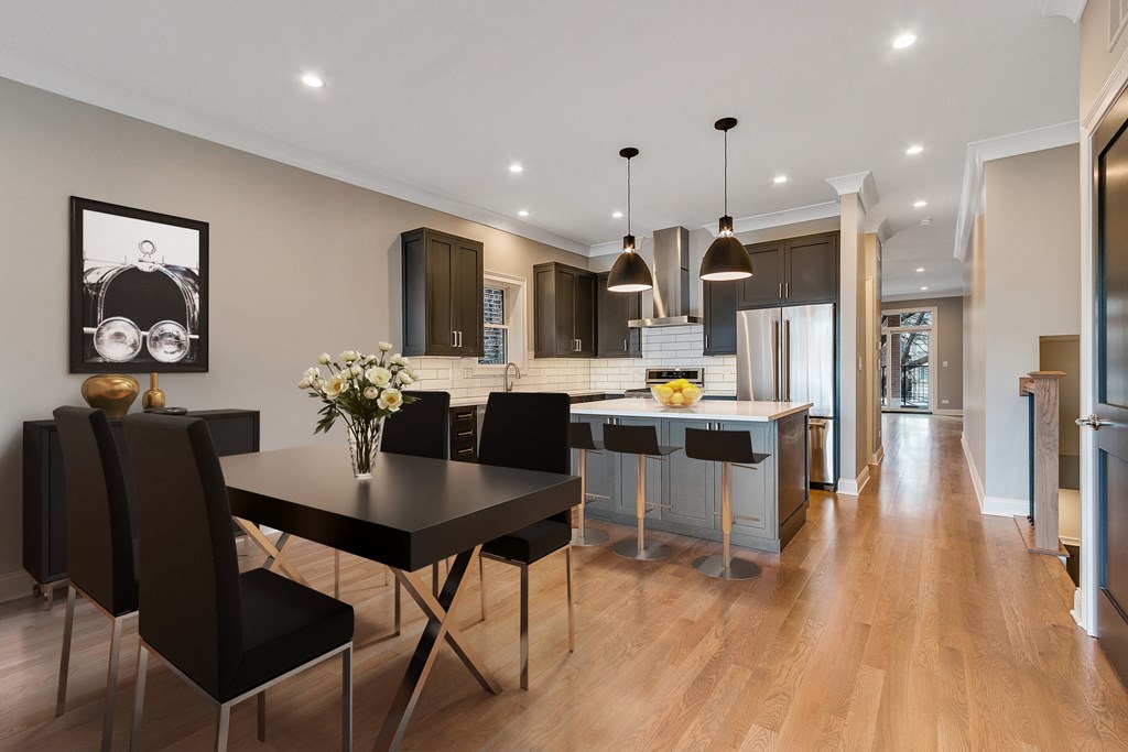 an open kitchen and dining area with a black table and chairs