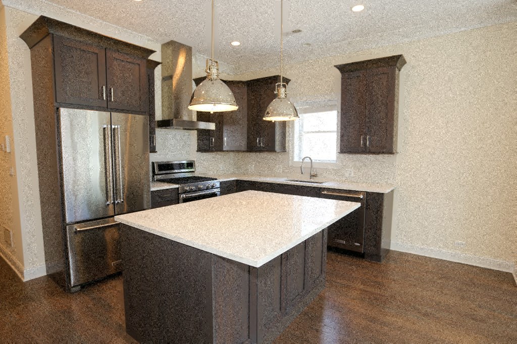 a kitchen with an island and a stainless steel refrigerator
