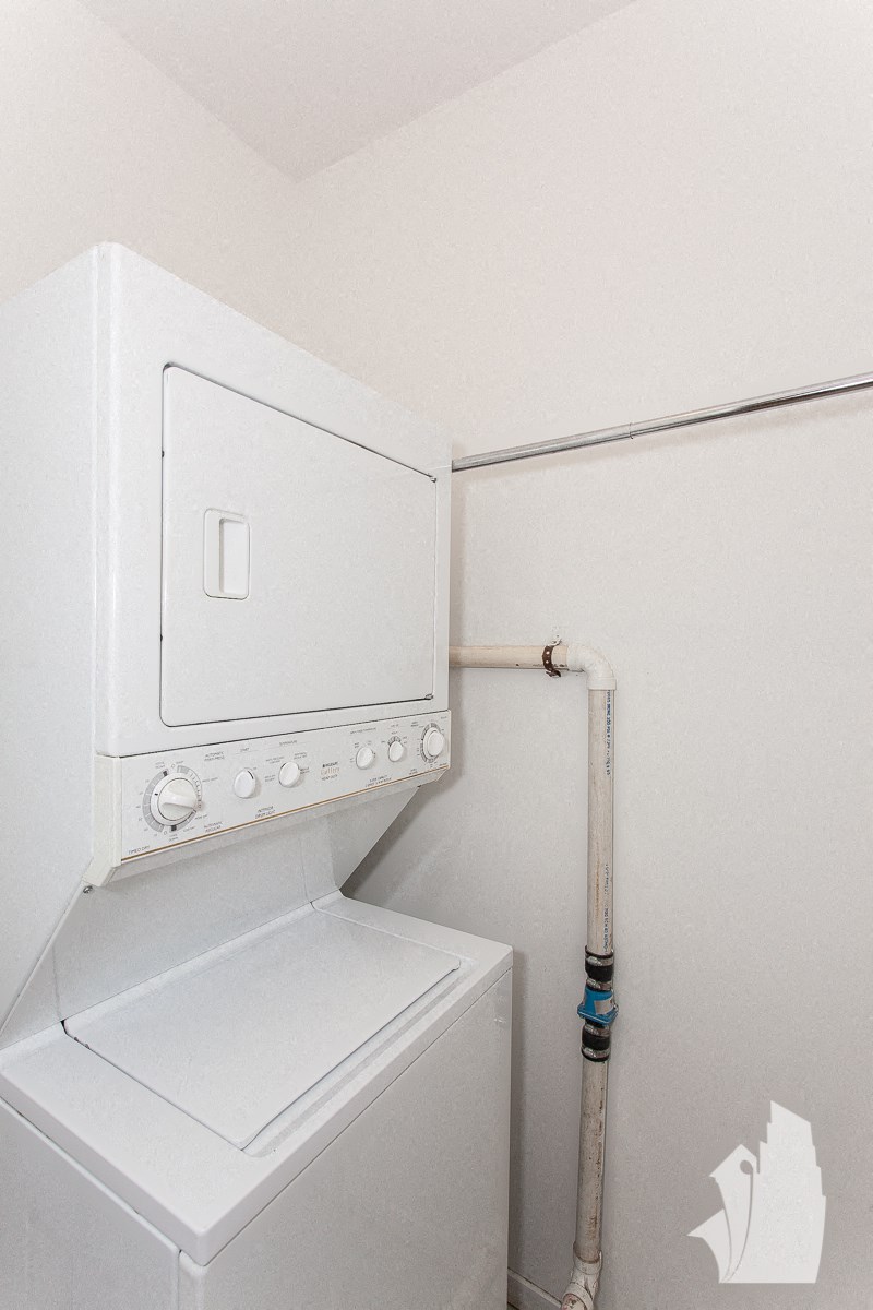 a white washer and dryer in a room with a white wall and a