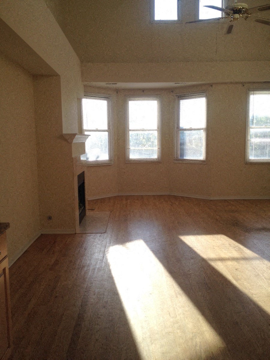 an empty living room with wood floors and windows