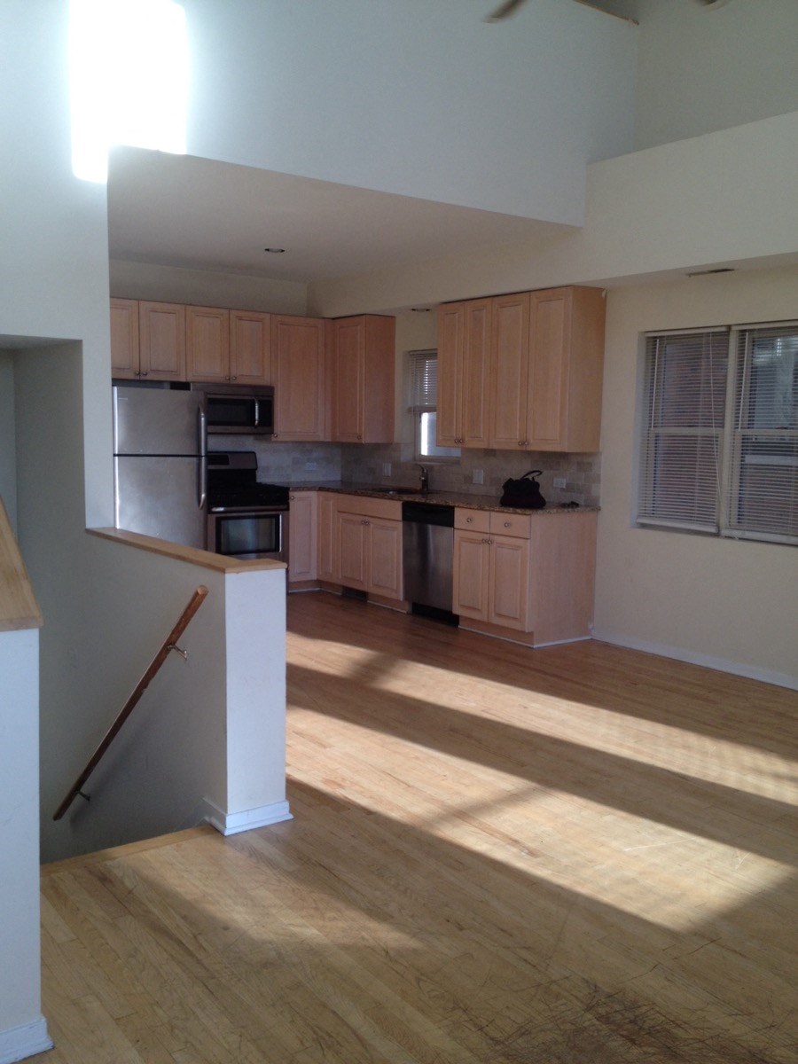 an empty kitchen with wooden cabinets and stainless steel appliances