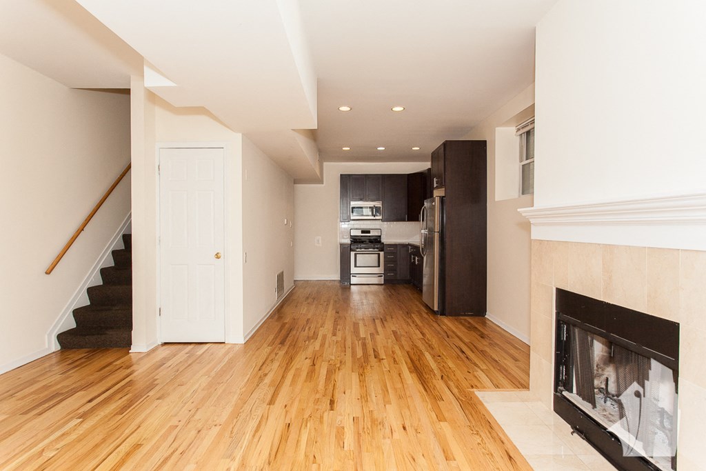 a living room with a fireplace and a wooden floor