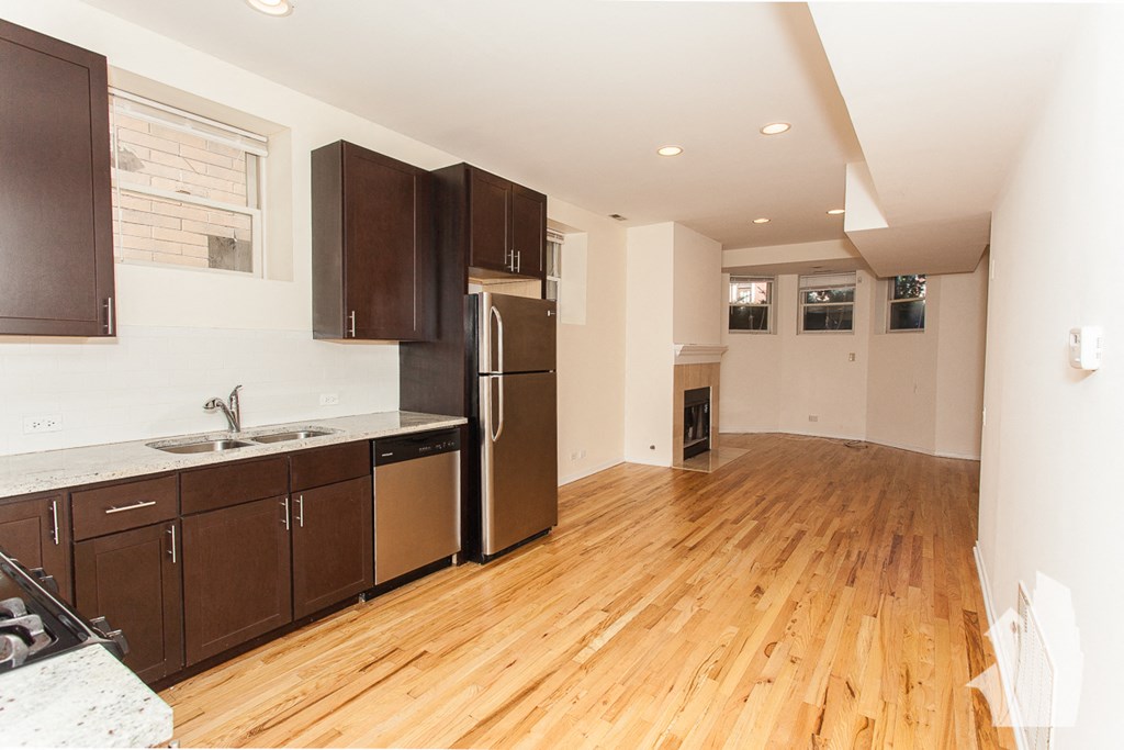 a kitchen with wooden floors and stainless steel appliances