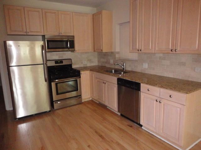 a kitchen with stainless steel appliances and white cabinets