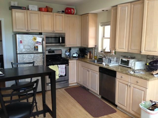 a kitchen with white cabinets and a black table