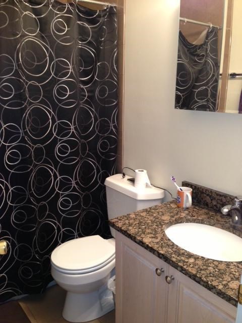 a bathroom with a toilet and a sink and a shower curtain