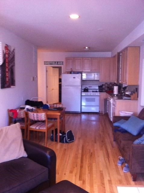 a living room and kitchen with a wooden floor