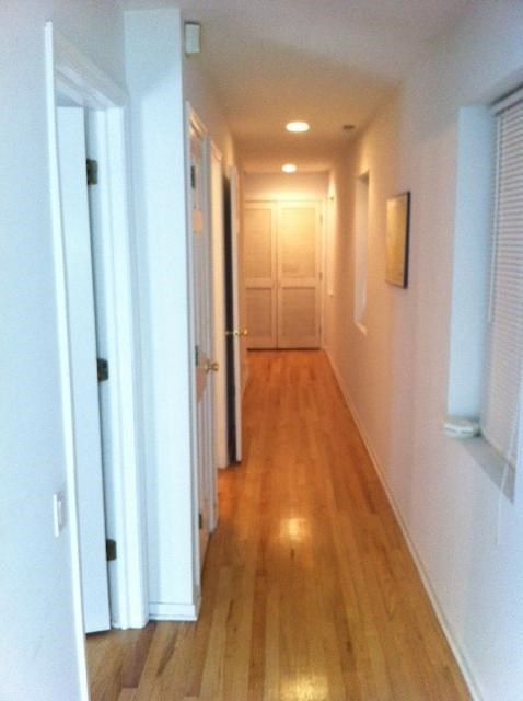 a hallway with a wood floor and a white door