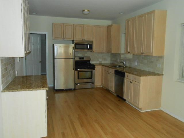 a kitchen with stainless steel appliances and a wooden floor