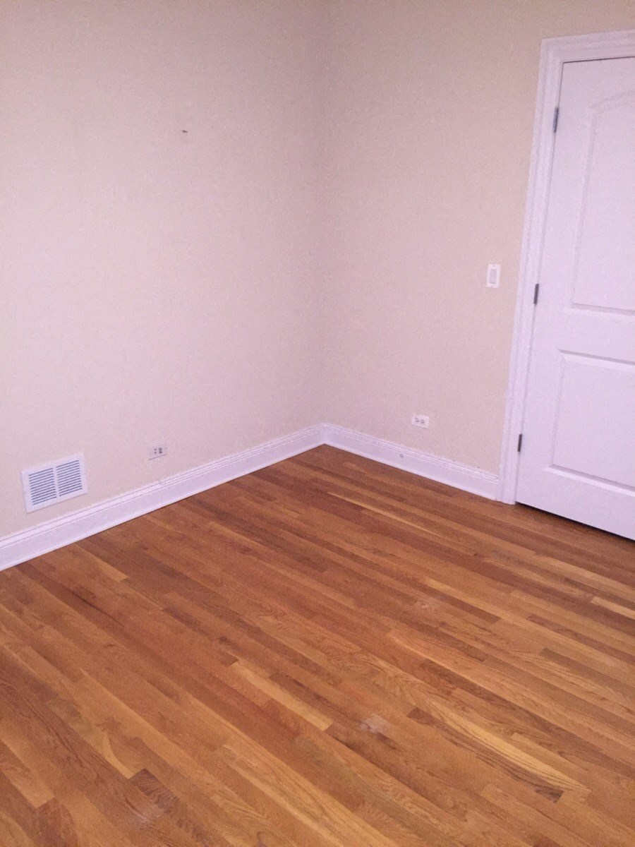 a room with a wooden floor and a white door